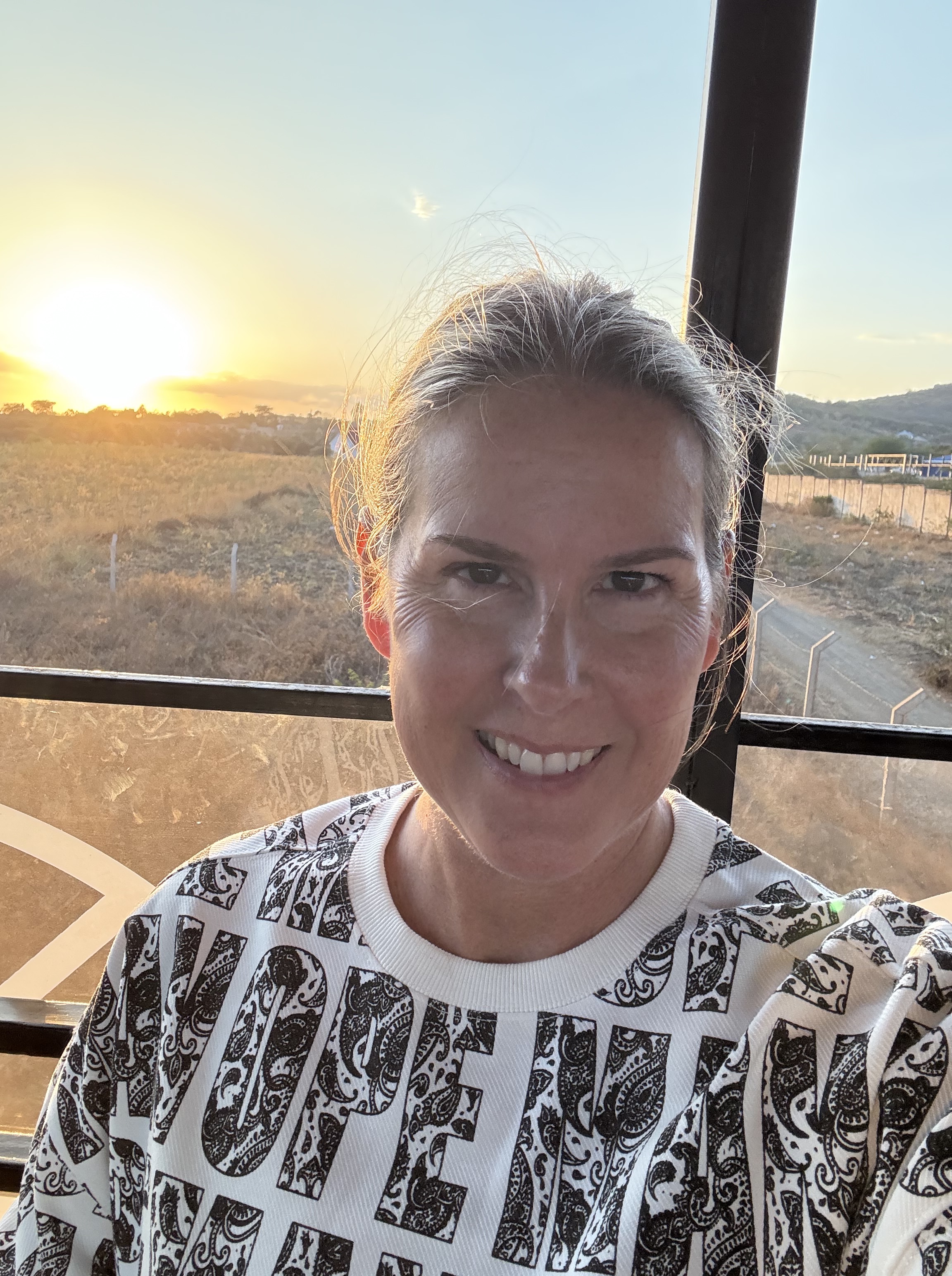Blonde woman (me) at sunset on rooftop deck